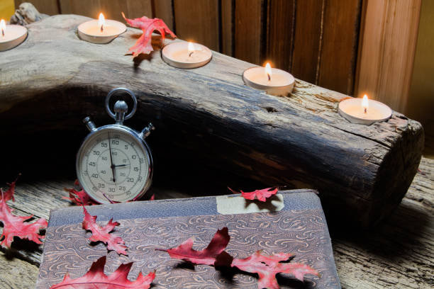 istock Old books and clock by candlelight. 1395565188