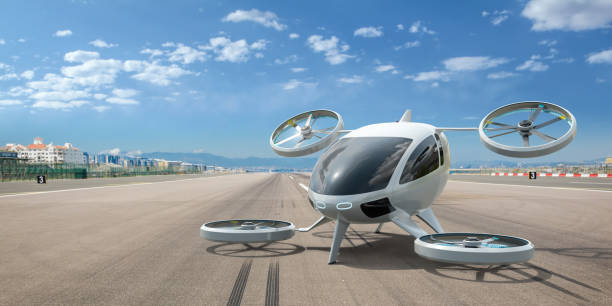 eVTOL Aircraft Parked On Empty Airport Runway A white electric powered Vertical Take Off and Landing eVTOL aircraft with four rotors parked on the empty runway of an airport, with distant buildings visible in the background. low carbon economy photos stock pictures, royalty-free photos & images
