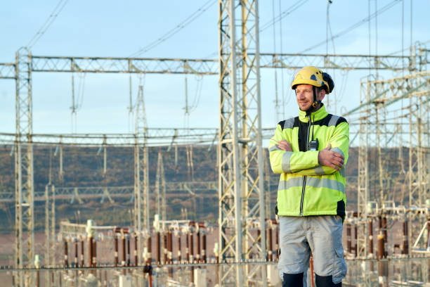 istock Electrical engineer standing near a high voltage power line. 1395568157