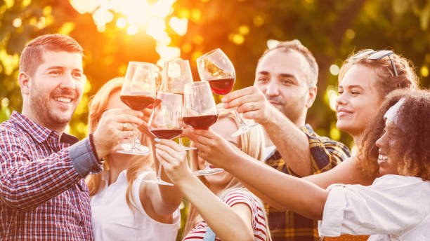 istock Happy friends toasting with red wine after harvesting 1395569389
