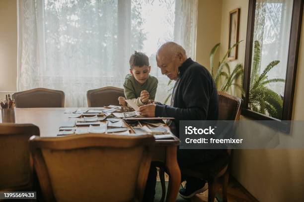 Grandfather Showing Pictures To Grandson Stock Photo - Download Image Now - Family Tree, Family, Memories