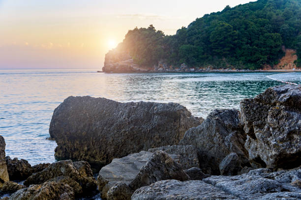 istock Sunset on the sea coast among rocks 1395570164