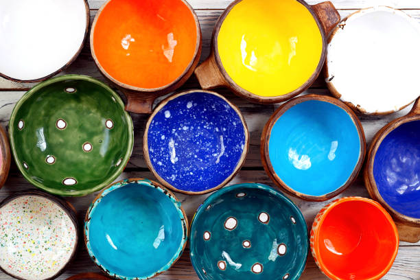 istock View from above on many different bright multicolored ceramic bowls and cups handcrafted on white wooden background. Top view. Background texture. 1395570170