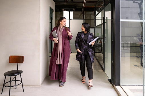 Female Saudi executives walking through modern office