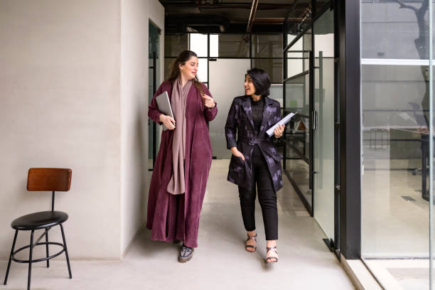 female saudi executives walking through modern office - anständig klädsel bildbanksfoton och bilder