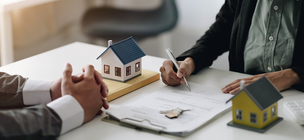 Agentes inmobiliarios explican el documento para los clientes que vienen a contactar para comprar una casa, comprar o vender el concepto de bienes raíces photo
