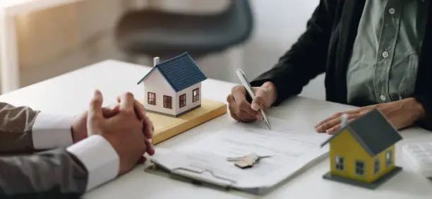 Photo of Real estate agents explain the document for customers who come to contact to buy a house, buy or sell real estate concept