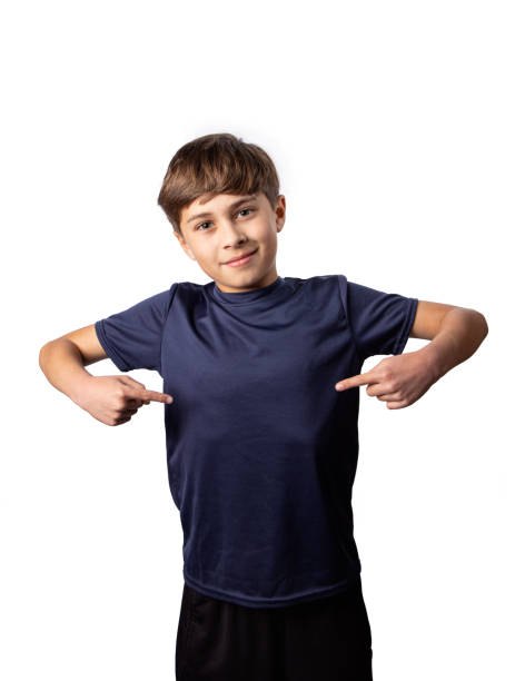 Boy pointing to blank tshirt on white background stock photo
