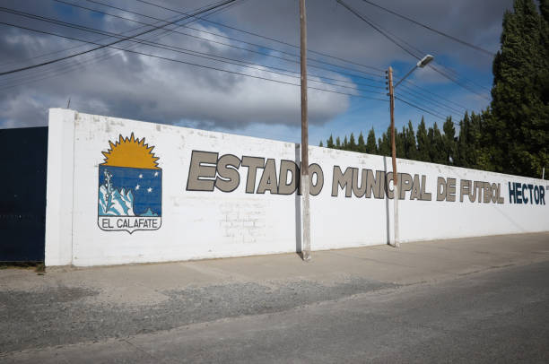 White brick wall with El Calafate coat of arms and Estadio Municipal de Futbol means Municipal Football Stadium El Calafate, Argentina - March, 2020: White brick wall with El Calafate coat of arms and Estadio Municipal de Futbol inscription means Municipal Football Stadium near entrance to soccer stadium club soccer photos stock pictures, royalty-free photos & images