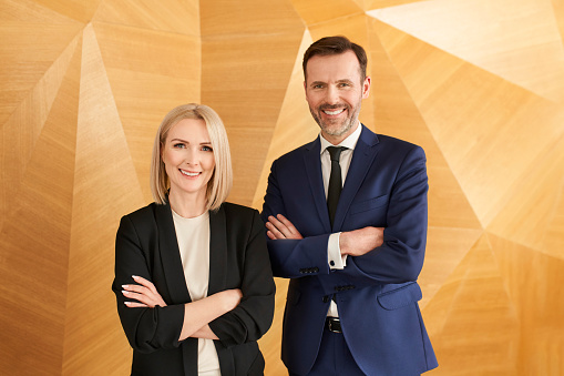 Portrait of two business professionals posing at corporate modern office