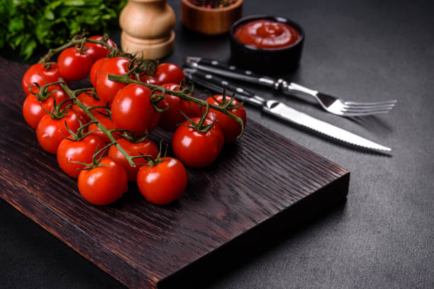 istock Fresh cherry tomatoes on a black background with spices 1395577509
