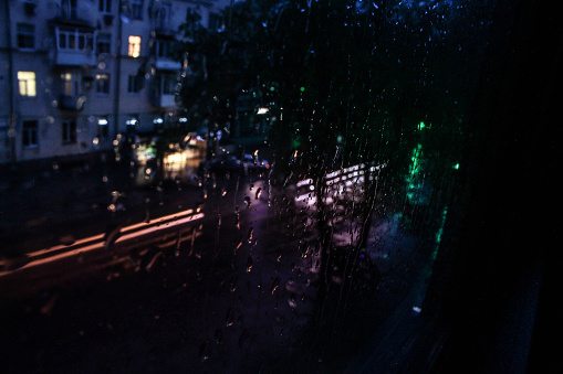 rainy weather. raindrops on glass. evening city