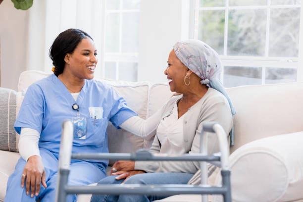 Nurse sits on the couch with her patient and they visit