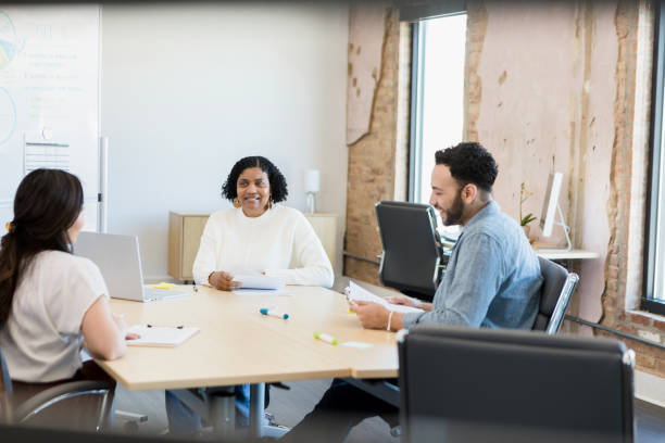 istock Female manager leads meeting with two employees 1395586893