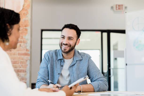 istock Male administrative assistant takes notes as female boss dictates 1395586914