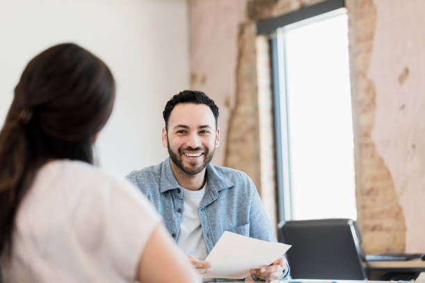 istock Male business owner smiles while interviewing unrecognizable woman 1395586919