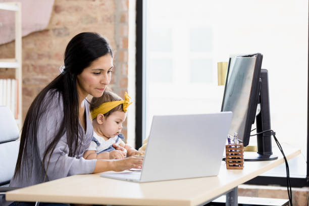 istock Mother works while baby daughter in lap entertains herself 1395587175