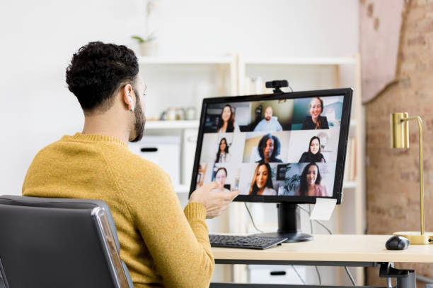 istock Man attends virtual staff meeting from home office 1395587182
