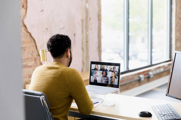 istock Over-the-shoulder view man attending virtual staff meeting 1395587203