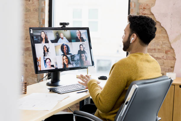 Team lead visits with team virtually The team lead visits with his team virtually to review feedback from the customer. video conference stock pictures, royalty-free photos & images