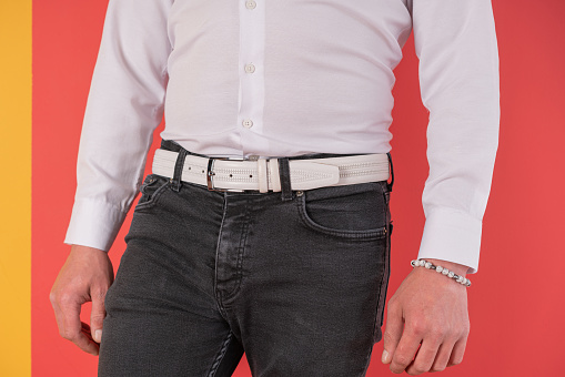 Close up man standing in black jeans and white leather belt