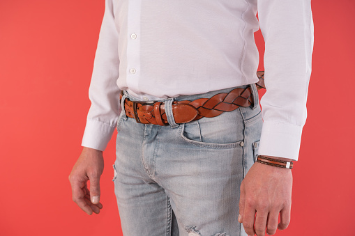 Close up man standing in blue jeans and brown leather belt