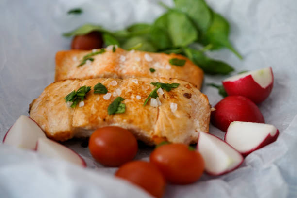 Baked salmon steak with tomato, baby spinach and radish