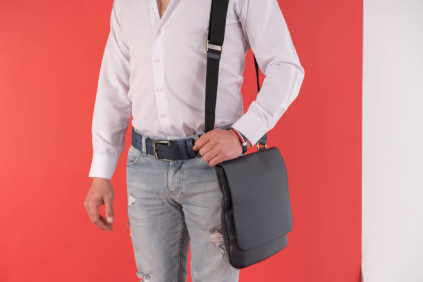 istock Man standing in blue jeans and holding blue hand bag over colored background. 1395593247