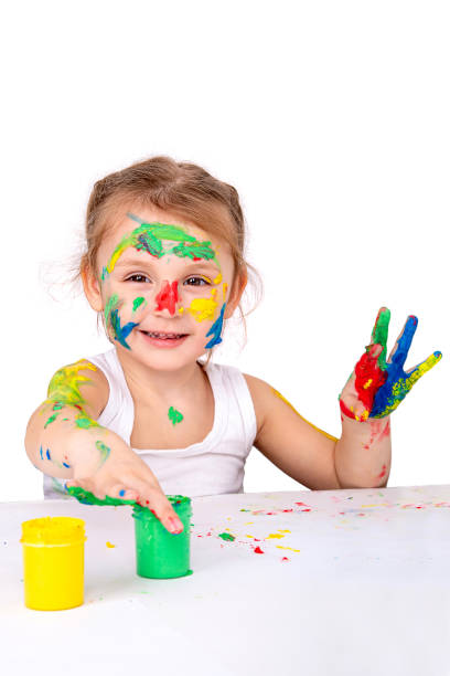 istock A cheerful girl with painted face and hands paints on a white background 1395593603
