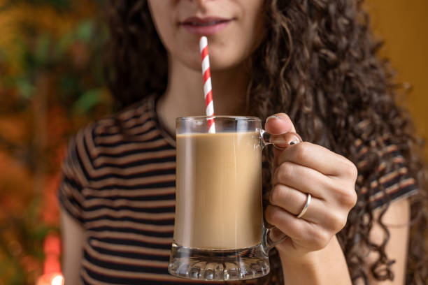 istock pretty woman with curly hair sitting on a table drinking cold coffee 1395593662
