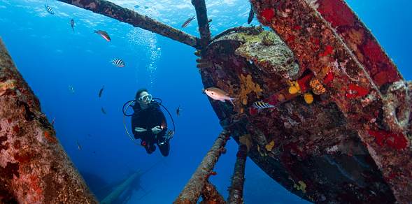 View of the Kittiwake Shipwreck and a female diver in Grand Cayman - Cayman Islands