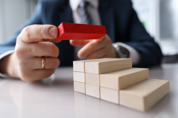 istock Man builds on table construction wooden blocks 1395595233