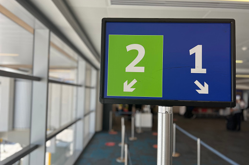 Green and blue sign showing groups 1 and 2 for passengers at the departure gate at the airport just before the boarding.