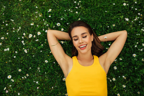 istock Smiling young woman lying on grass 1395597229