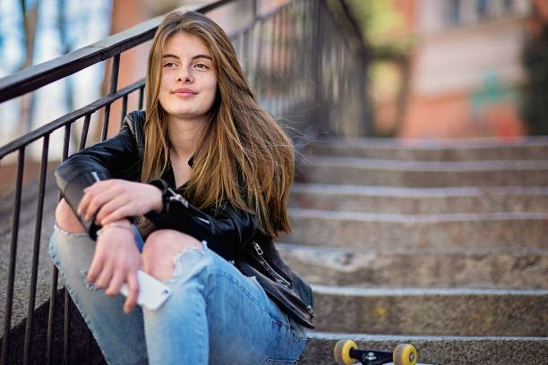 Beautiful girl posing on the steps in an autumn park