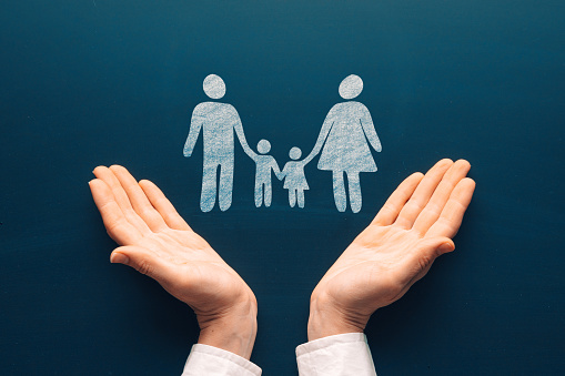 Family life care insurance concept. Female tender hands with a family symbol drawing on chalkboard. Protecting the rights of people and minorities. Love for the children idea.