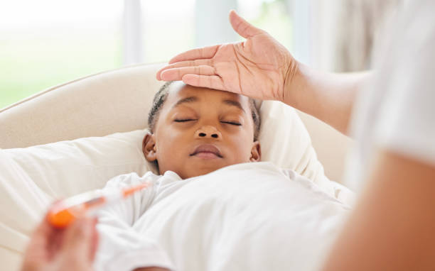 istock Shot of an unrecognisable mother using her hand to check her sick daughter's temperature at home 1395601088