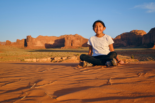 A Native American Navajo young girl playing in the desert at Monument Valley USA.