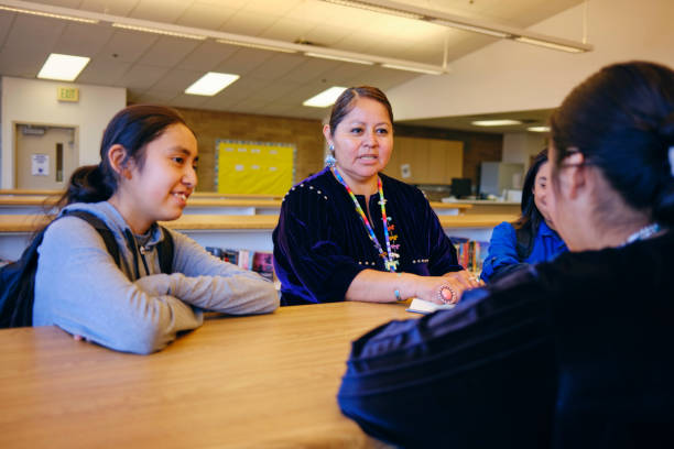 istock High School Teacher and Students in a School Library 1395601777