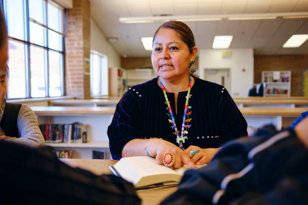 gymnasiallehrer und schüler in einer schulbibliothek - navajo american culture indigenous culture women stock-fotos und bilder