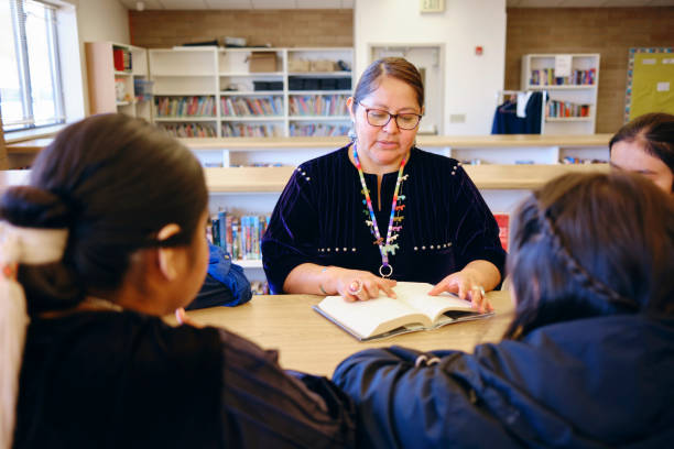 istock High School Teacher and Students in a School Library 1395601872