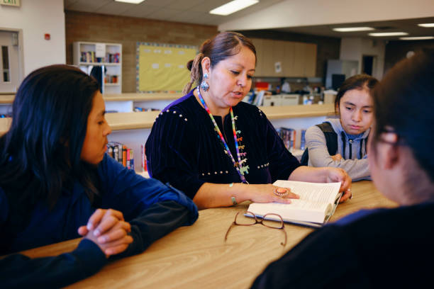 istock High School Teacher and Students in a School Library 1395601877
