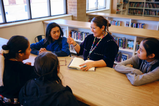 istock High School Teacher and Students in a School Library 1395601884