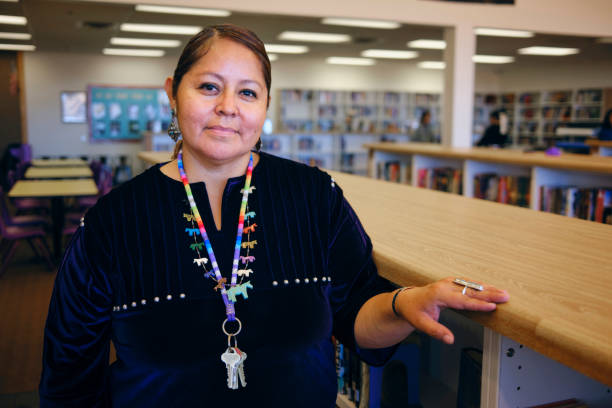 High School Teacher in a Library A portrait of a Native American Navajo high school teacher in a school library. indian woman smiling stock pictures, royalty-free photos & images