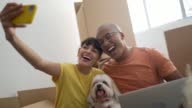 istock Happy young couple taking a selfie while packing moving boxes at home 1395602035