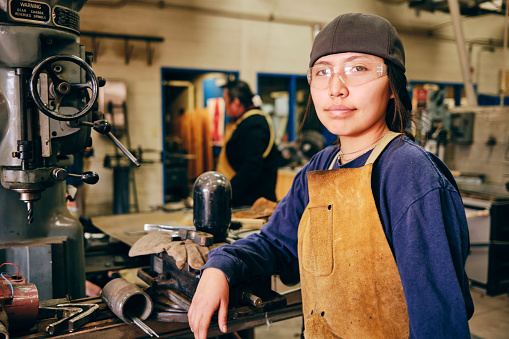 A teenage Native American Navajo girl, in an automotive workshop at a high school.