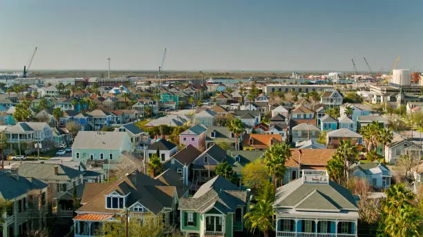 Aerial view of Galveston, Texas on a bright sunny day. The drone flies over historic homes and residential streets in the East End. 

Authorization was obtained from the FAA for this operation in restricted airspace.