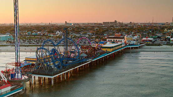 Aerial shot of the historic pier and the beach in Galveston, Texas at sunset. \n\nAuthorization was obtained from the FAA for this operation in restricted airspace.