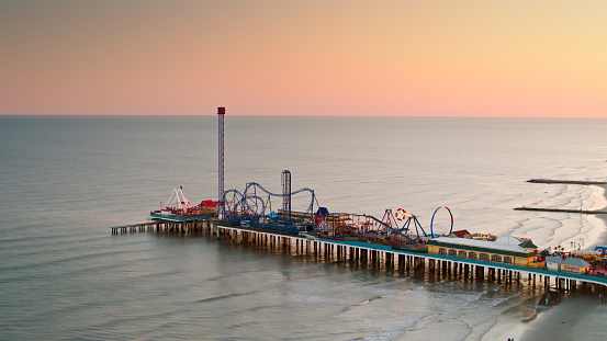 Aerial shot of the historic pier and the beach in Galveston, Texas at sunset. \n\nAuthorization was obtained from the FAA for this operation in restricted airspace.