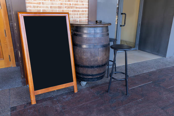 istock large wooden barrel used as a table and empty black restaurant menu advertising board on the outside of a restaurant 1395606645
